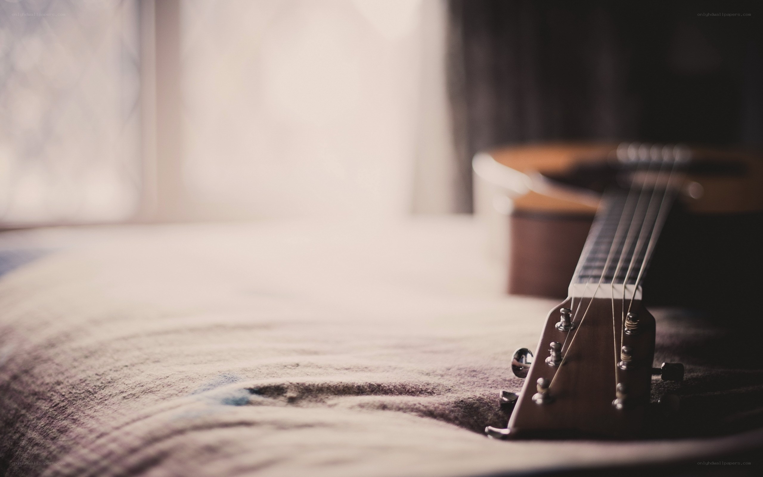 Acoustic guitar on a bed