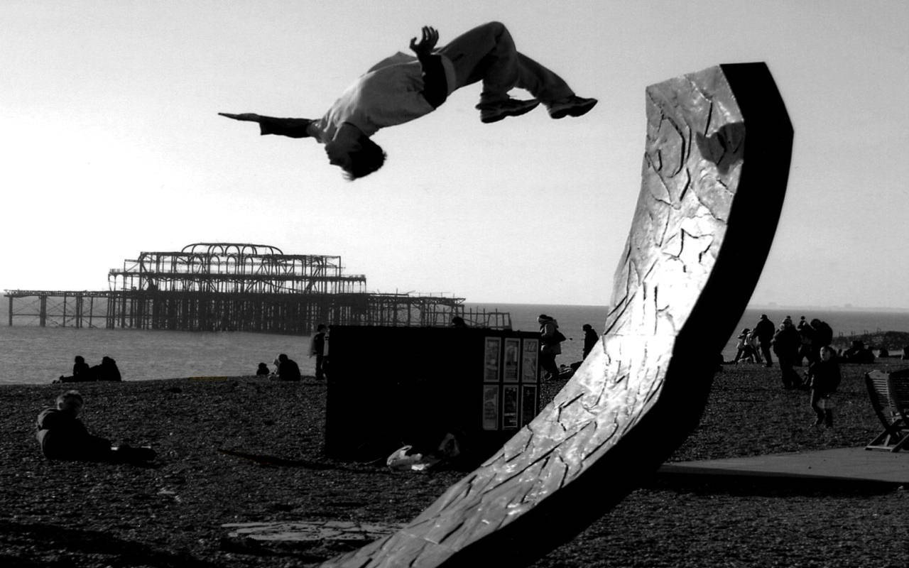 Acrobat performing flip on beach