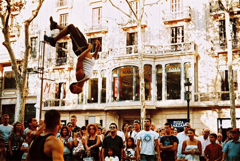 Acrobat performs flip in street