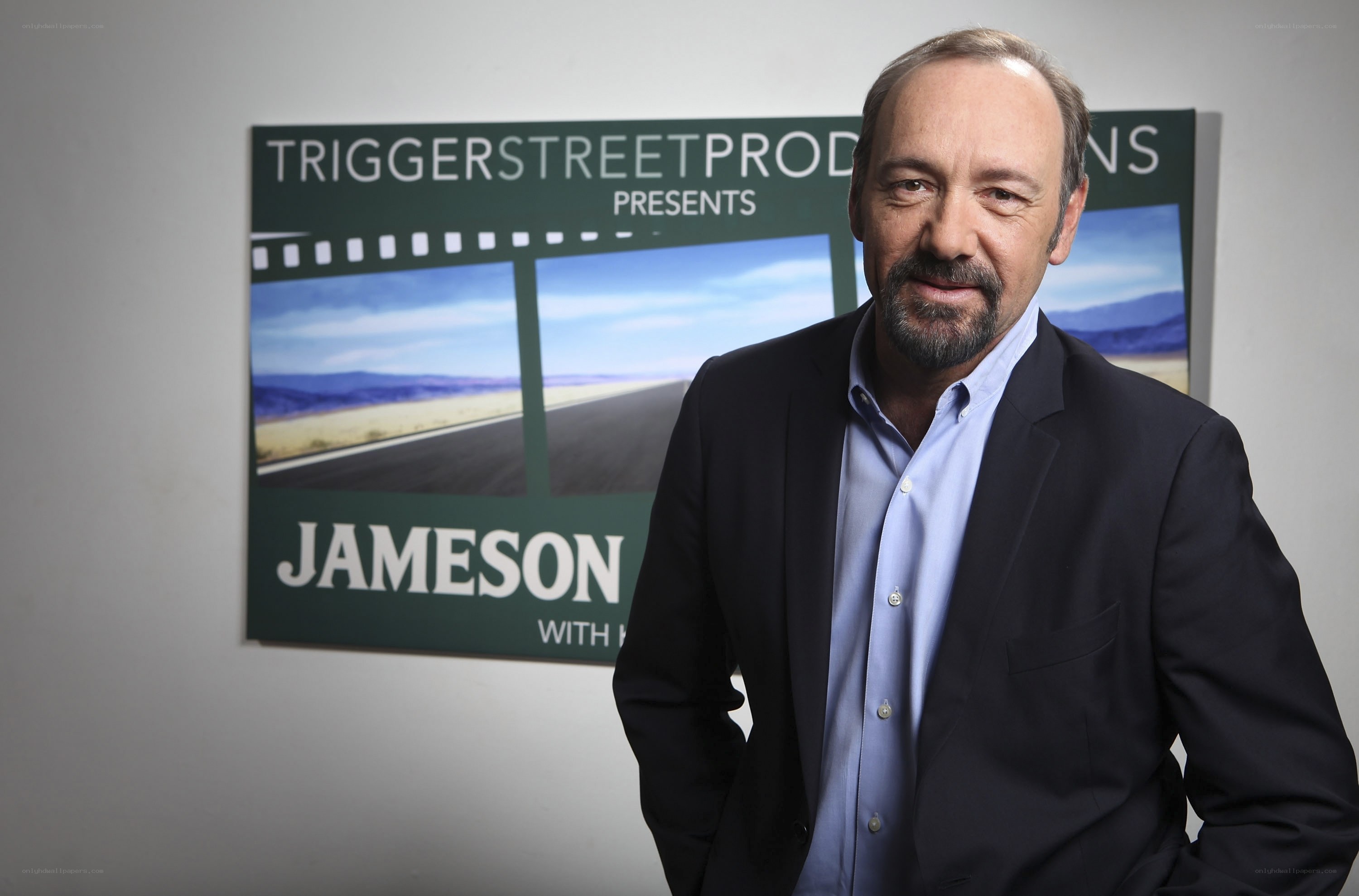 actor in front of promotional sign