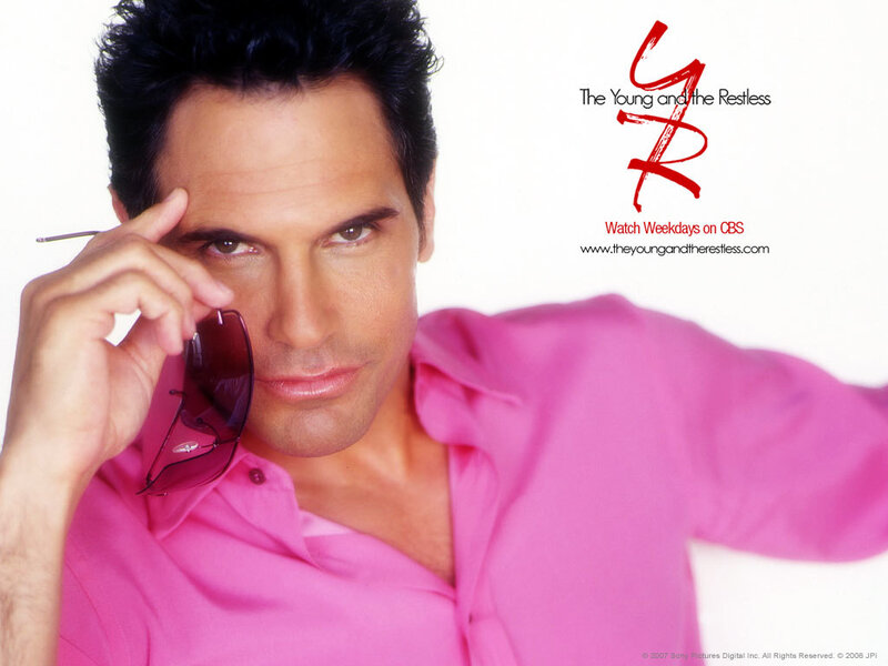 actor in pink shirt holding sunglasses