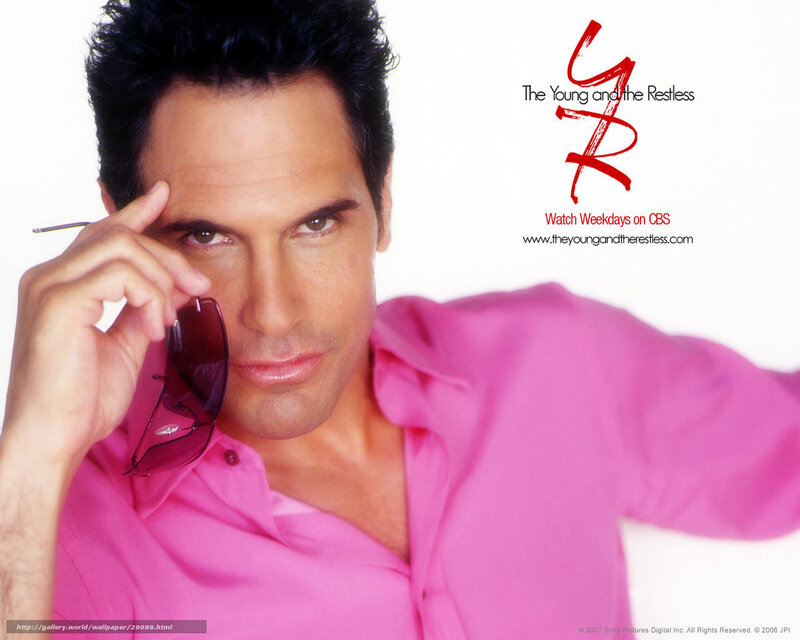 actor in pink shirt holding sunglasses