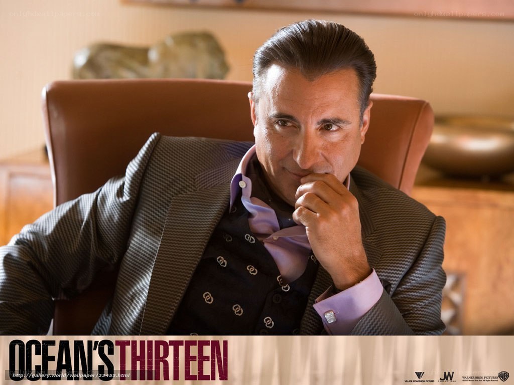 actor in suit sitting in chair