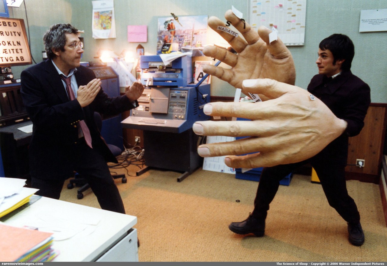 Actors with giant hands in office