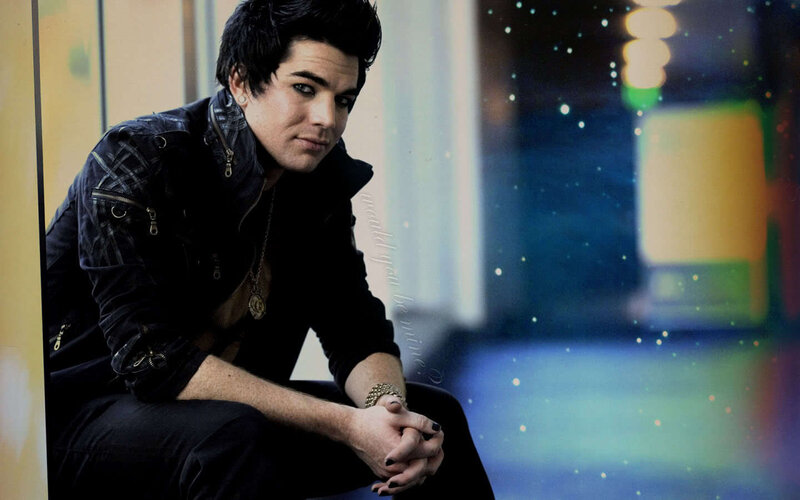 Adam Lambert sitting in a city