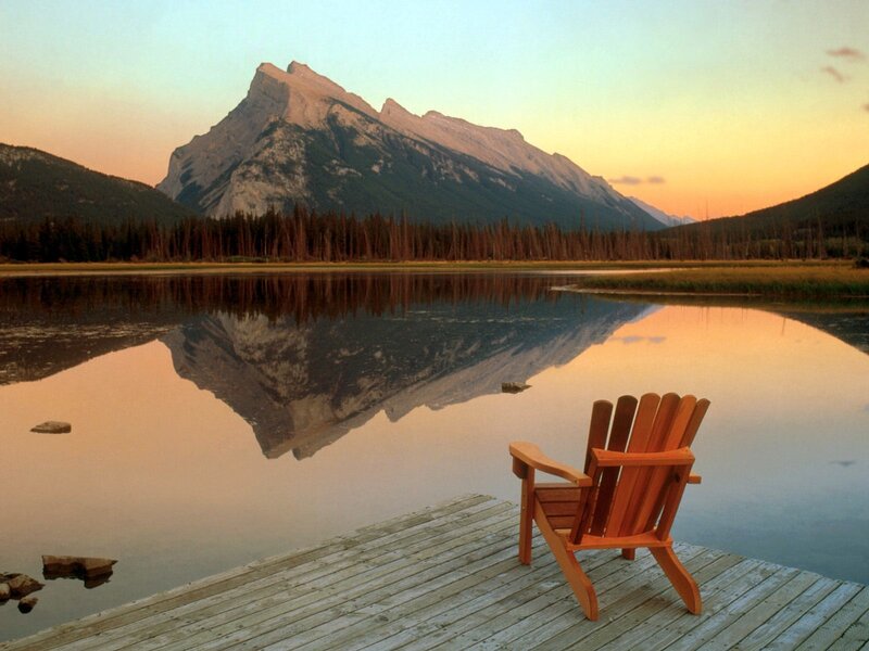 Adirondack chair by a mountain lake