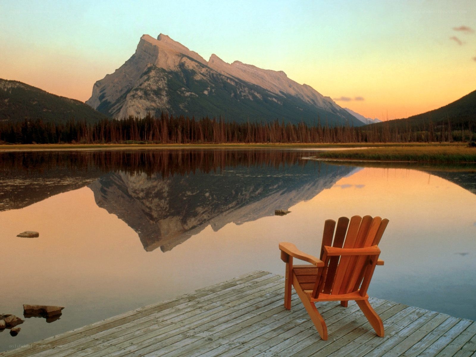 Adirondack chair by a mountain lake