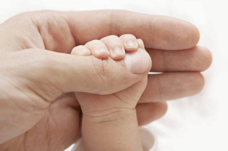 Adult Hand Holding Baby Foot — White