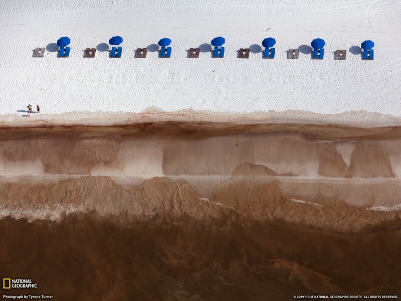 Aerial view of beach with blue umbrellas