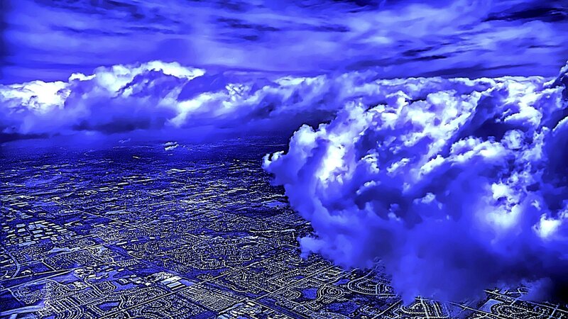 Aerial view of city under blue clouds