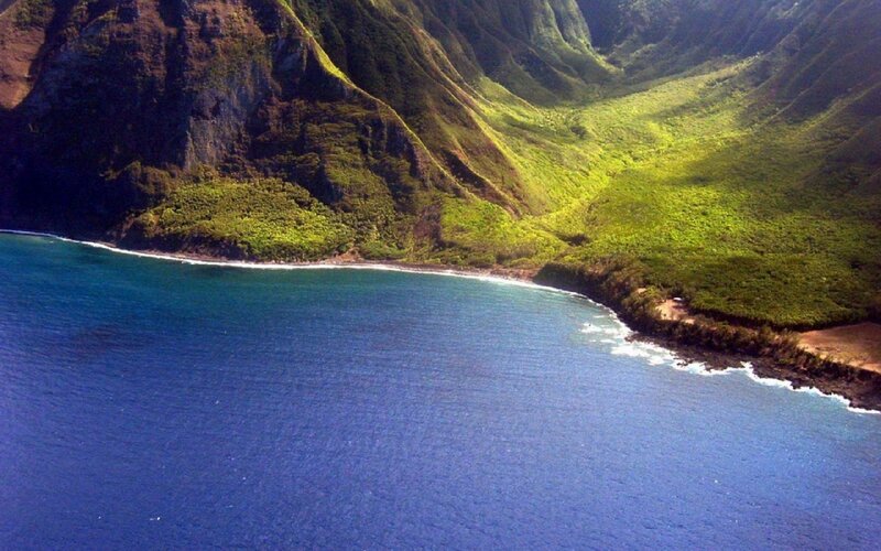 Aerial view of lush green mountains and blue ocean
