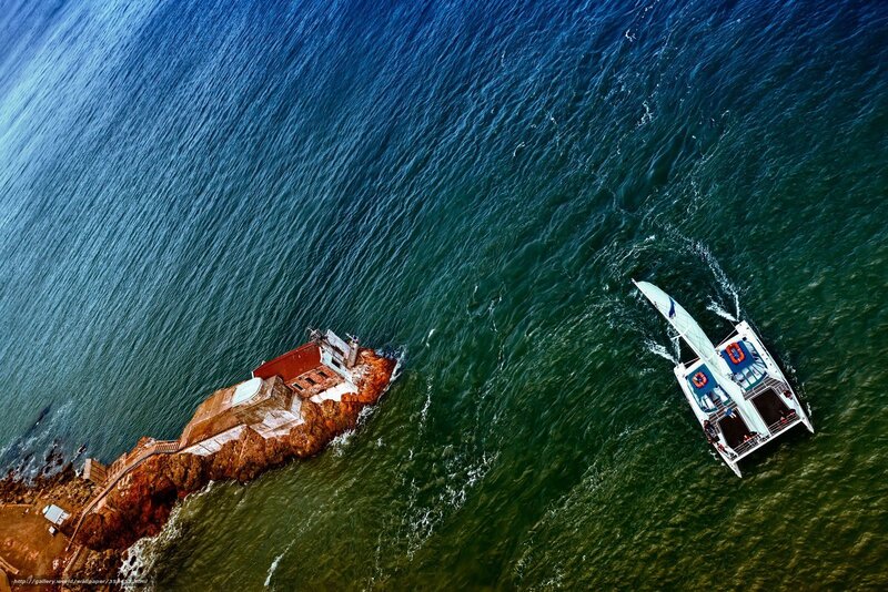 Aerial view of sailboat near lighthouse