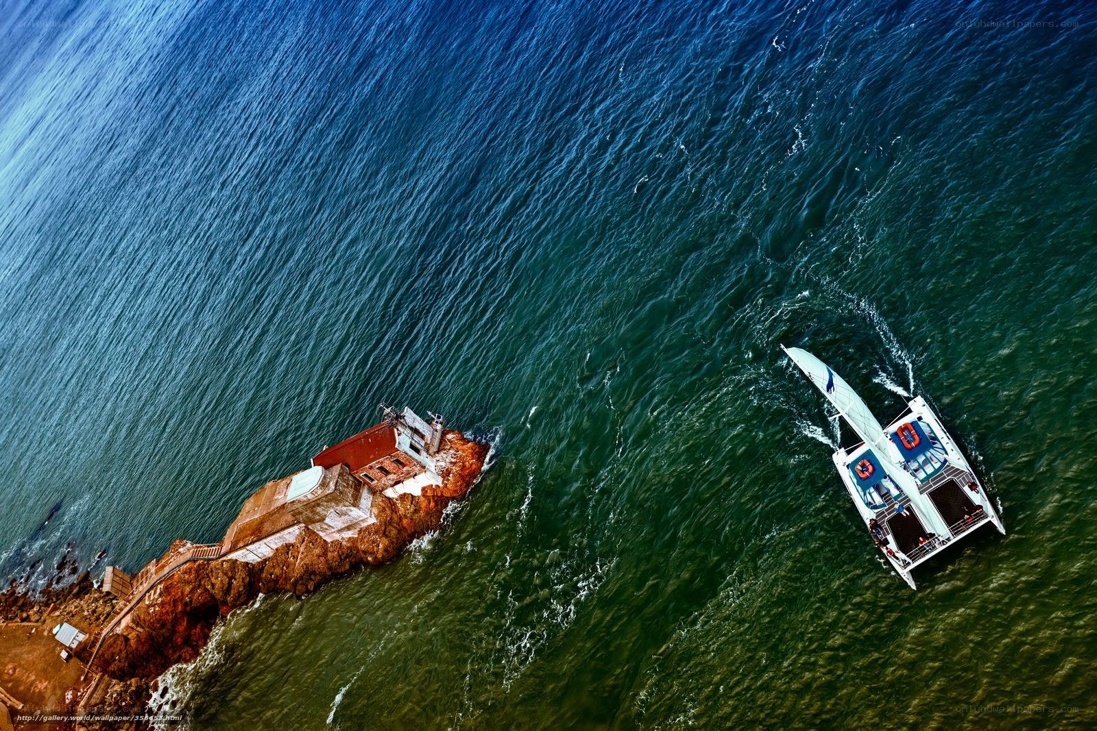 Aerial view of sailboat near lighthouse