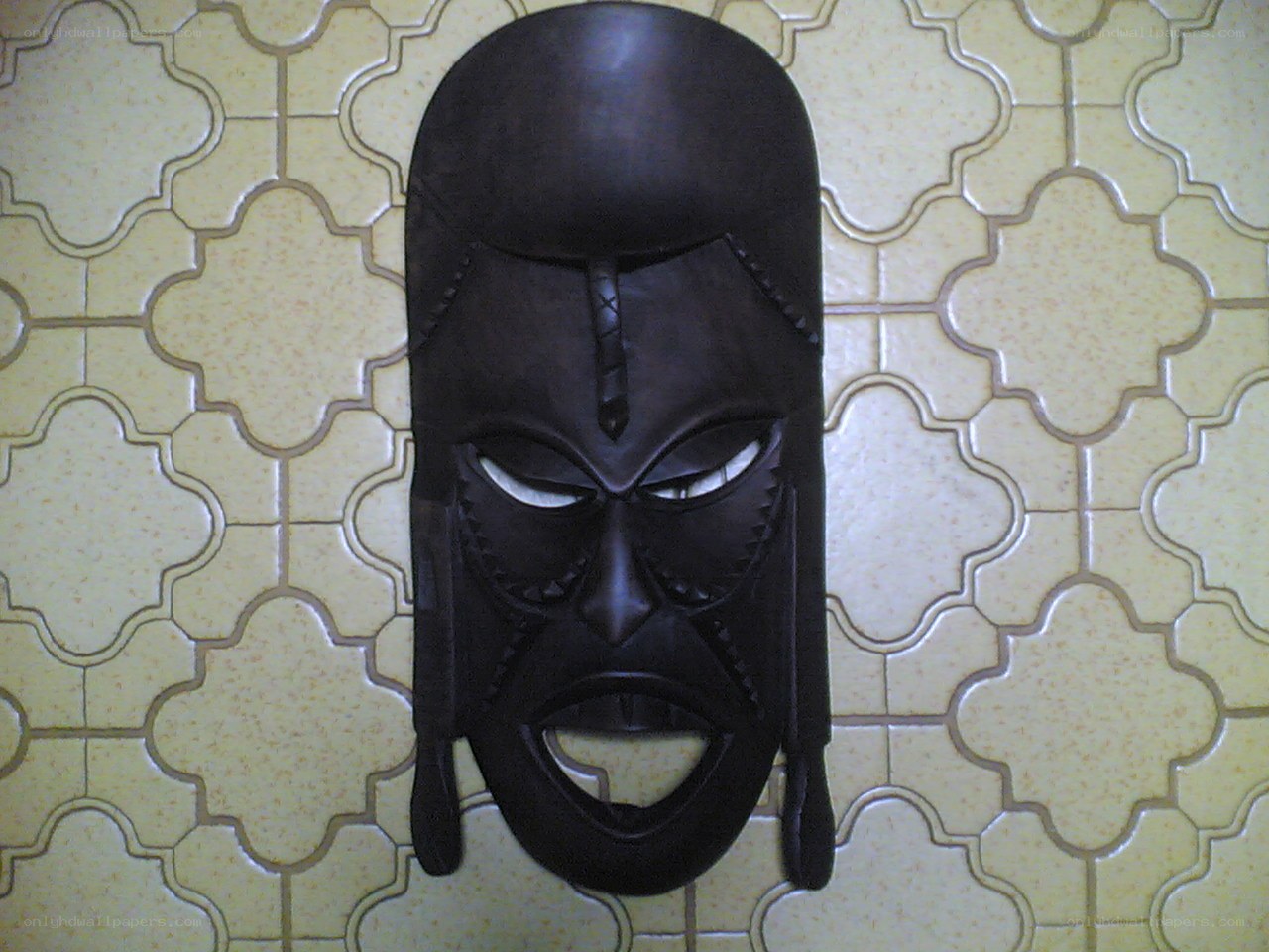 African mask on tiled wall