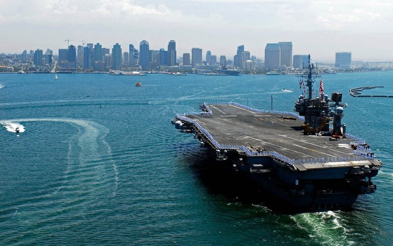 Aircraft Carrier in Harbor — Blue, Calm, Afternoon, Photograph, City Skyline, Boats