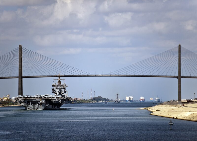 Aircraft carrier passing under a bridge