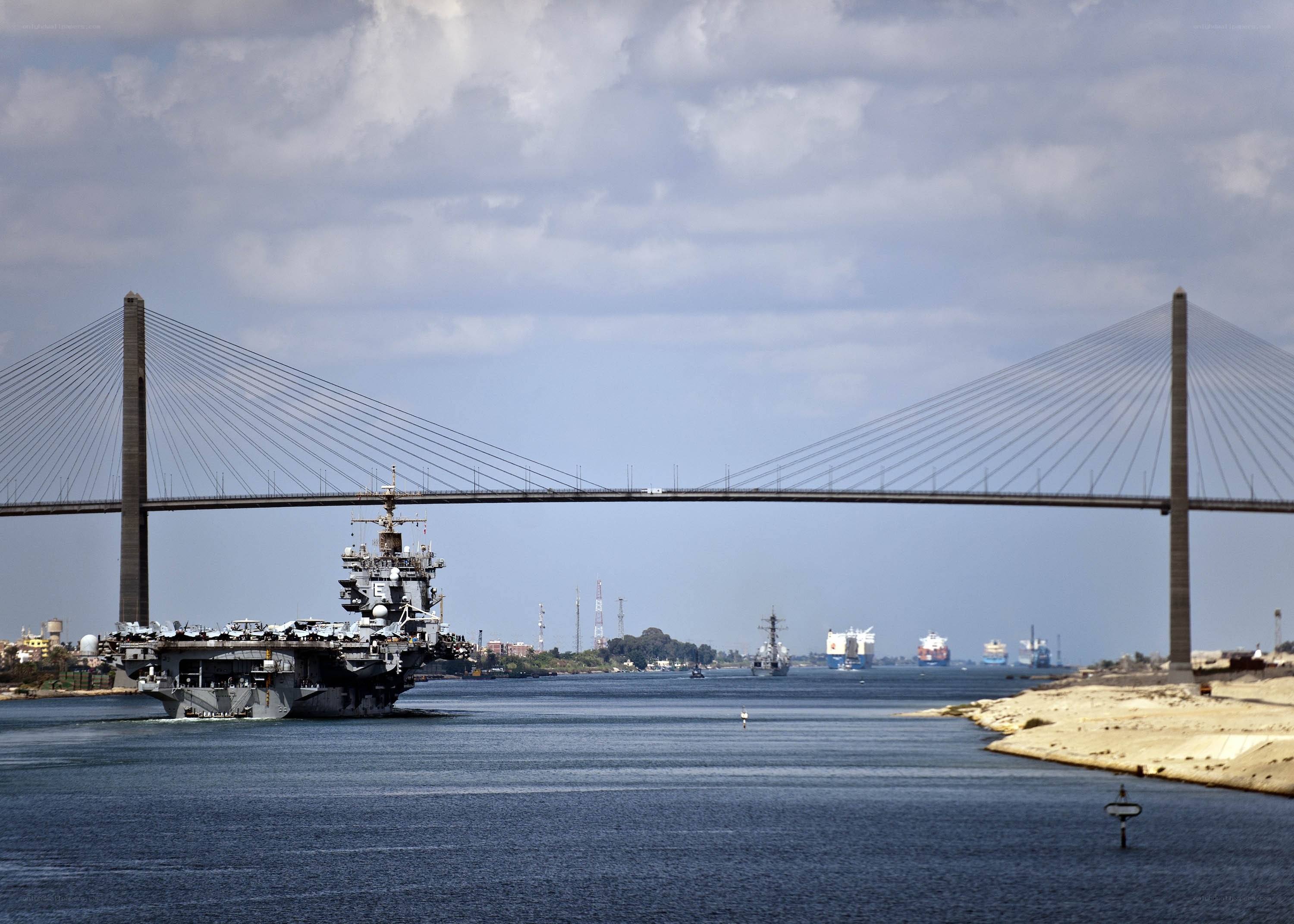 Aircraft carrier passing under a bridge