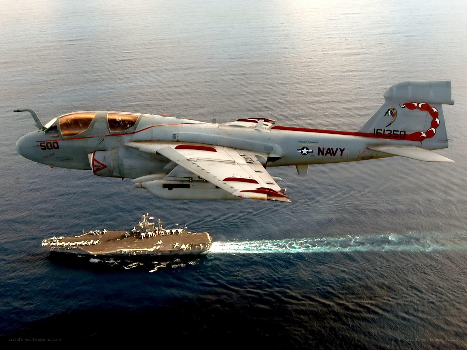 Aircraft flying over aircraft carrier