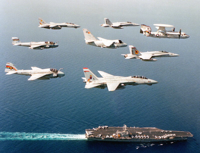 Aircraft flying over an aircraft carrier