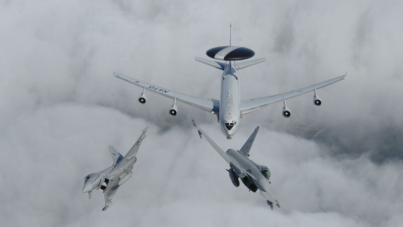 Aircraft in formation above clouds
