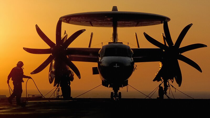 Aircraft on aircraft carrier at sunset