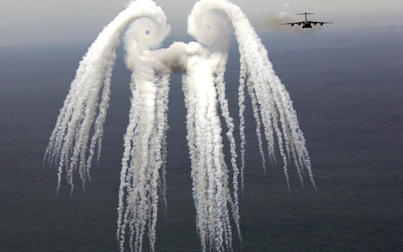 aircraft releasing flares over ocean