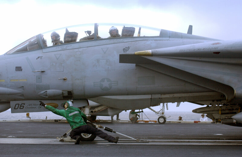Aircrew preparing jet on aircraft carrier