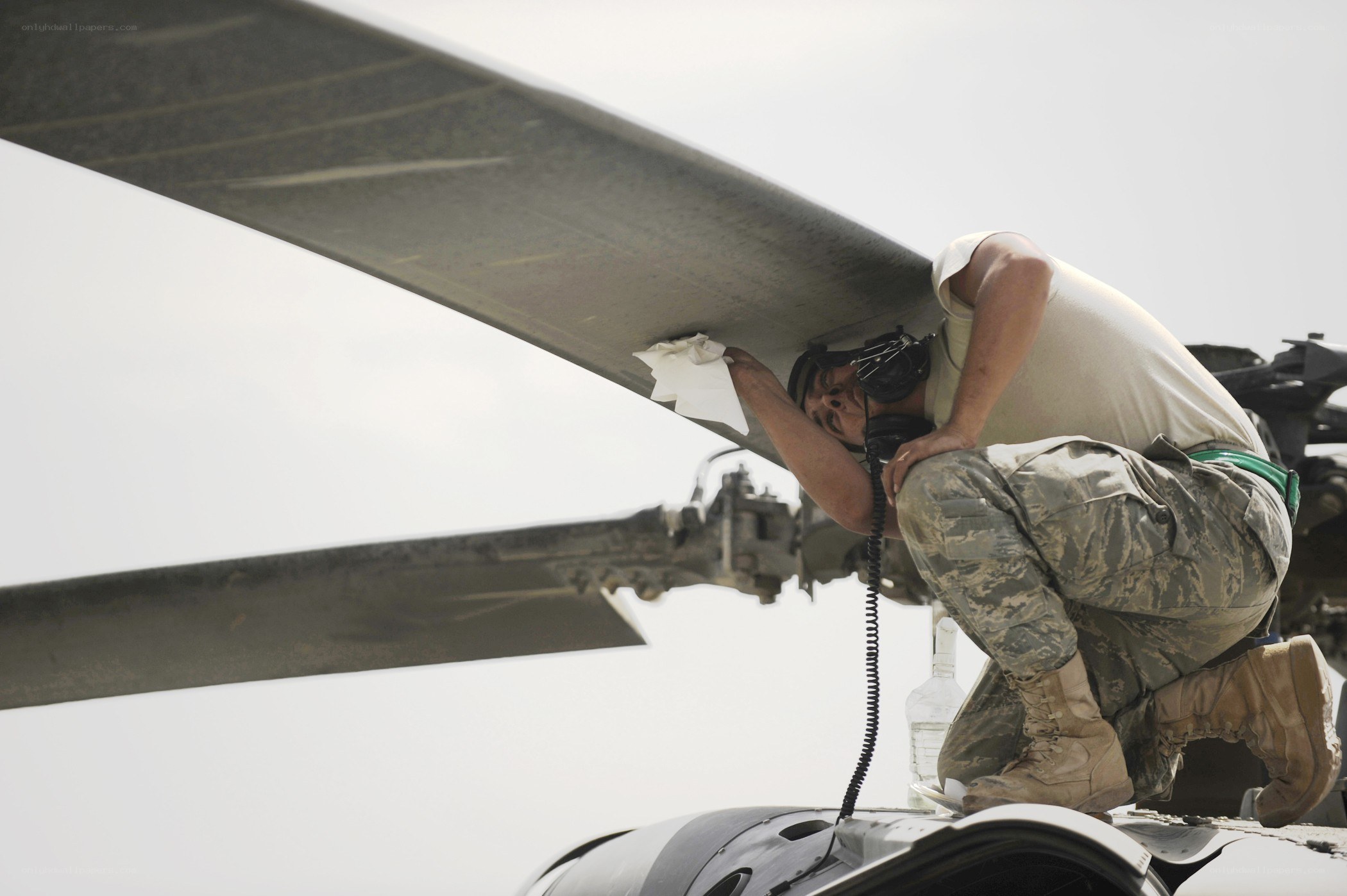 Airman cleaning helicopter rotor
