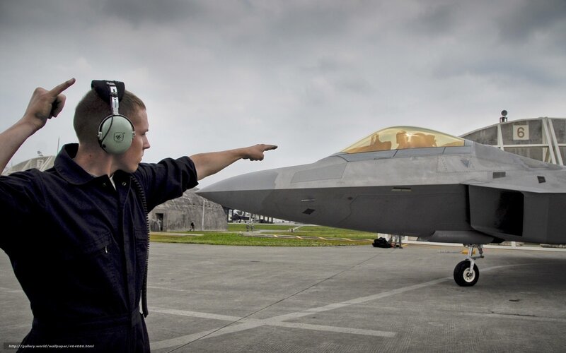 Airman directing fighter jet