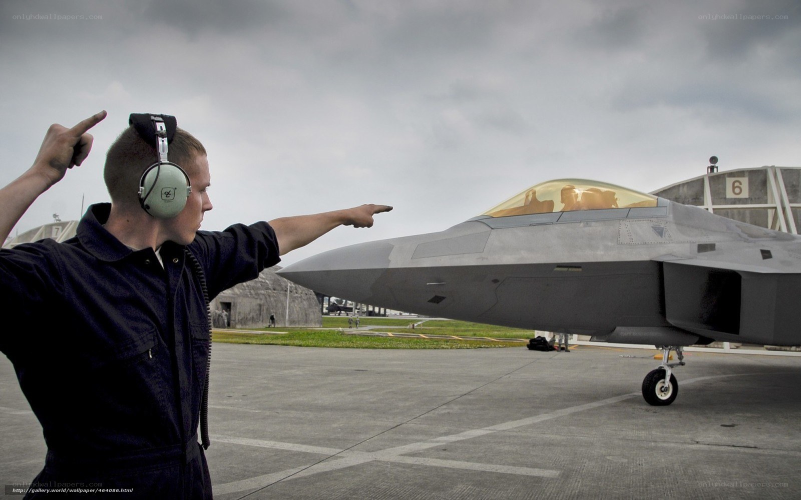 Airman directing fighter jet