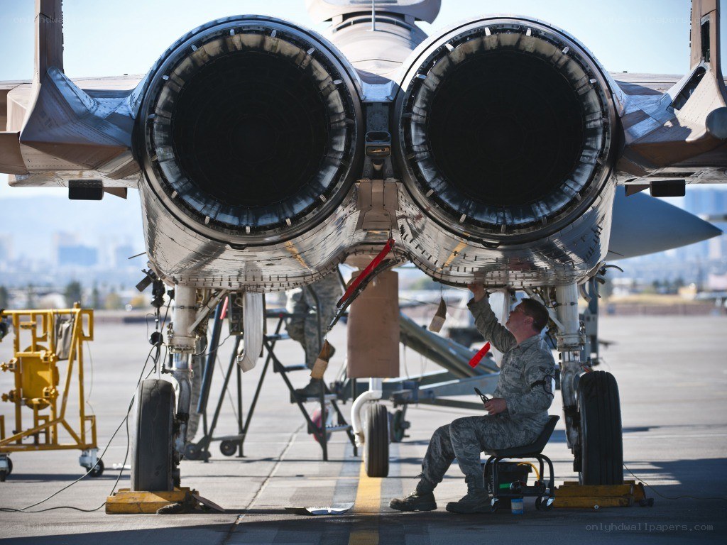 Airman servicing jet engines