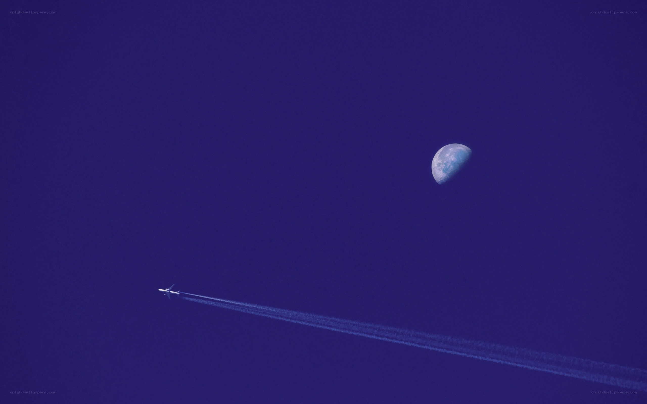 Airplane and moon in blue sky