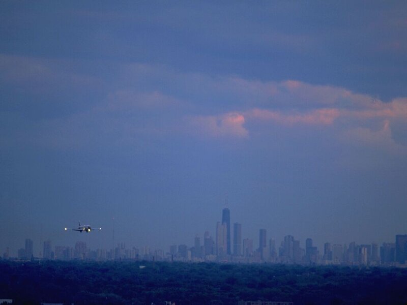 Airplane approaching city skyline