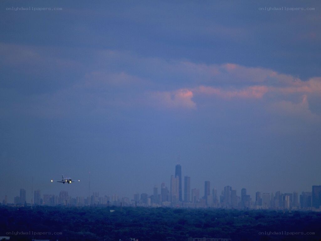 Airplane approaching city skyline