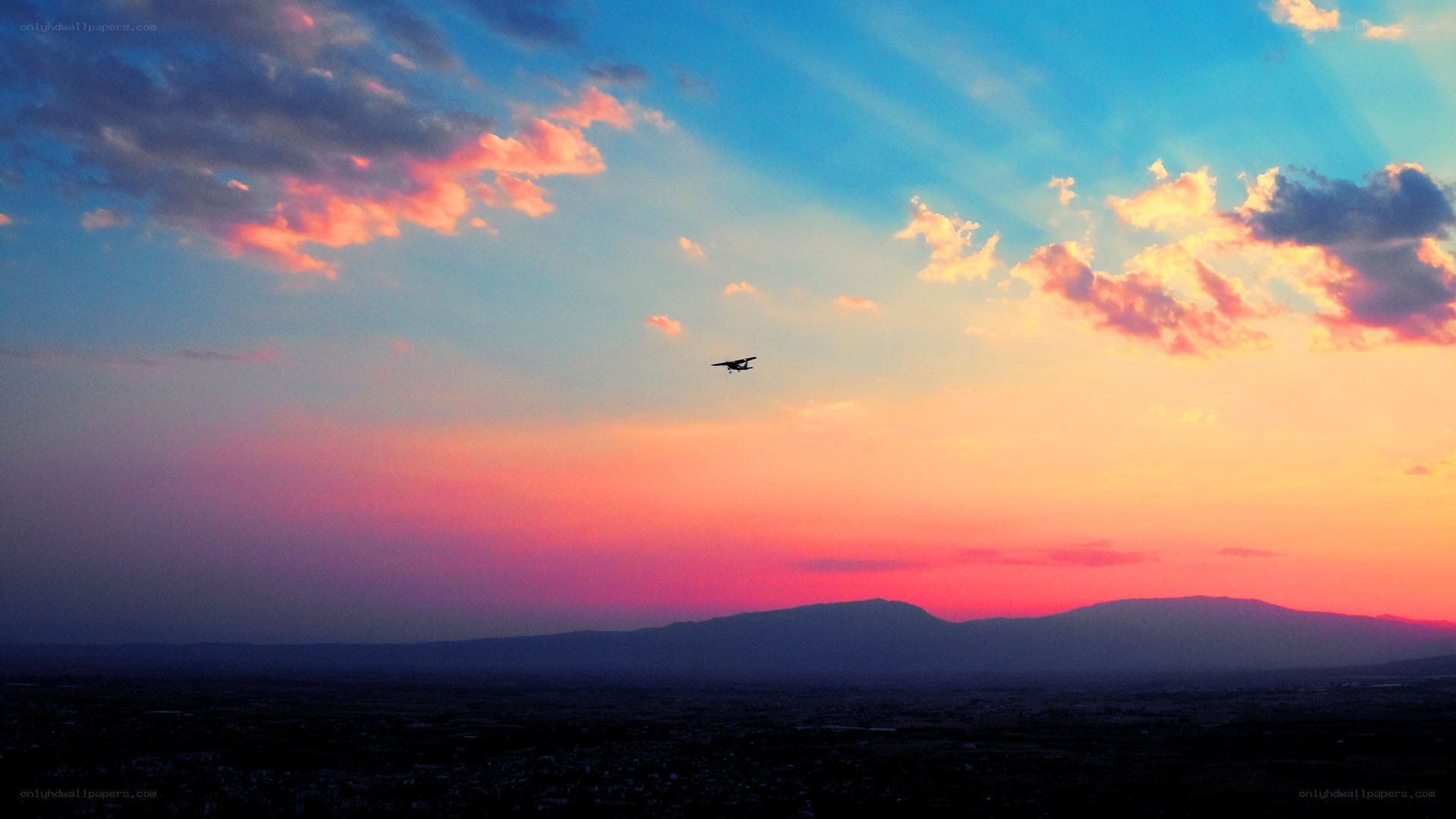 Airplane at sunset over mountains