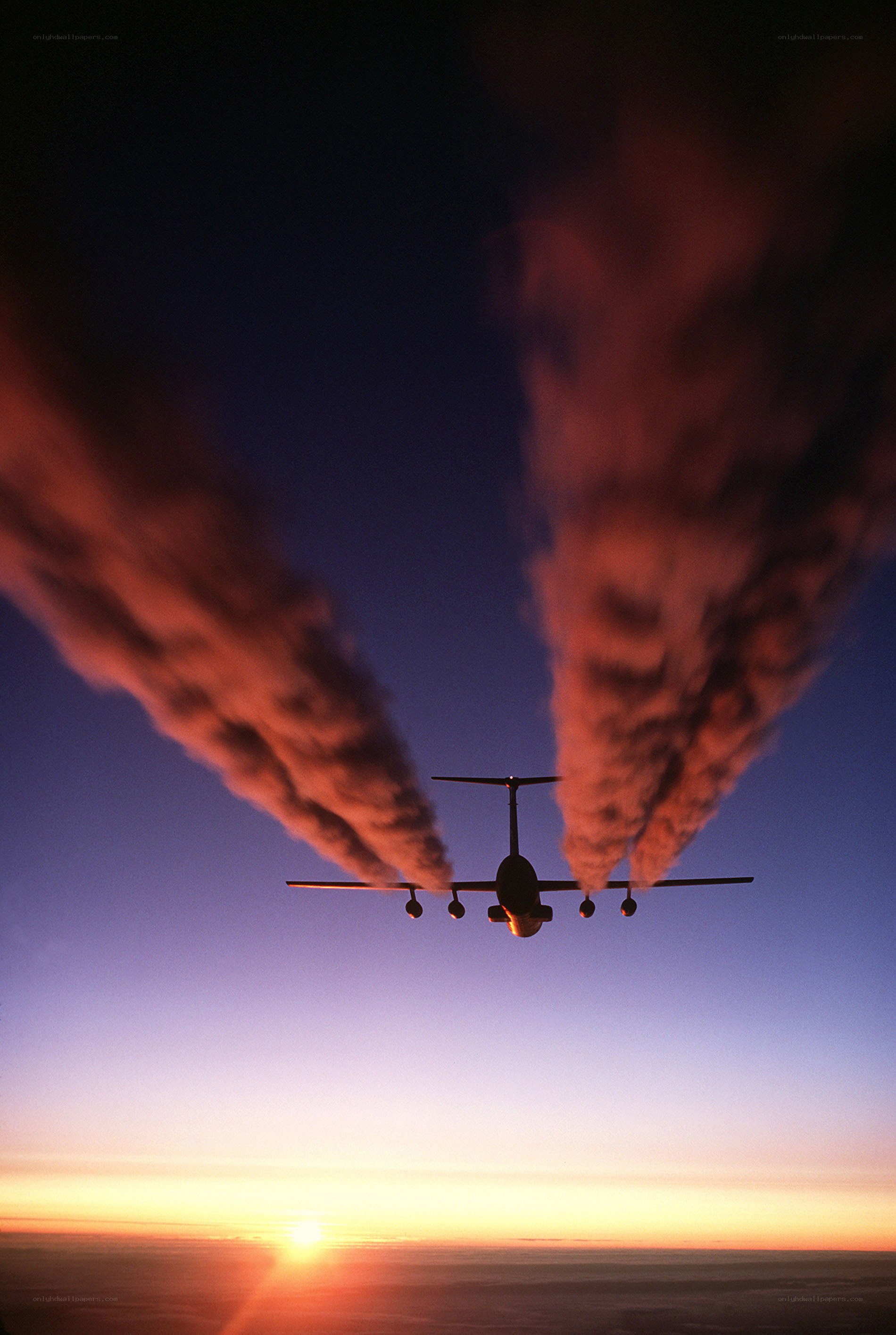 Airplane at sunset with contrails