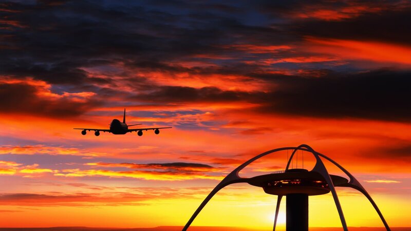 Airplane at sunset with control tower