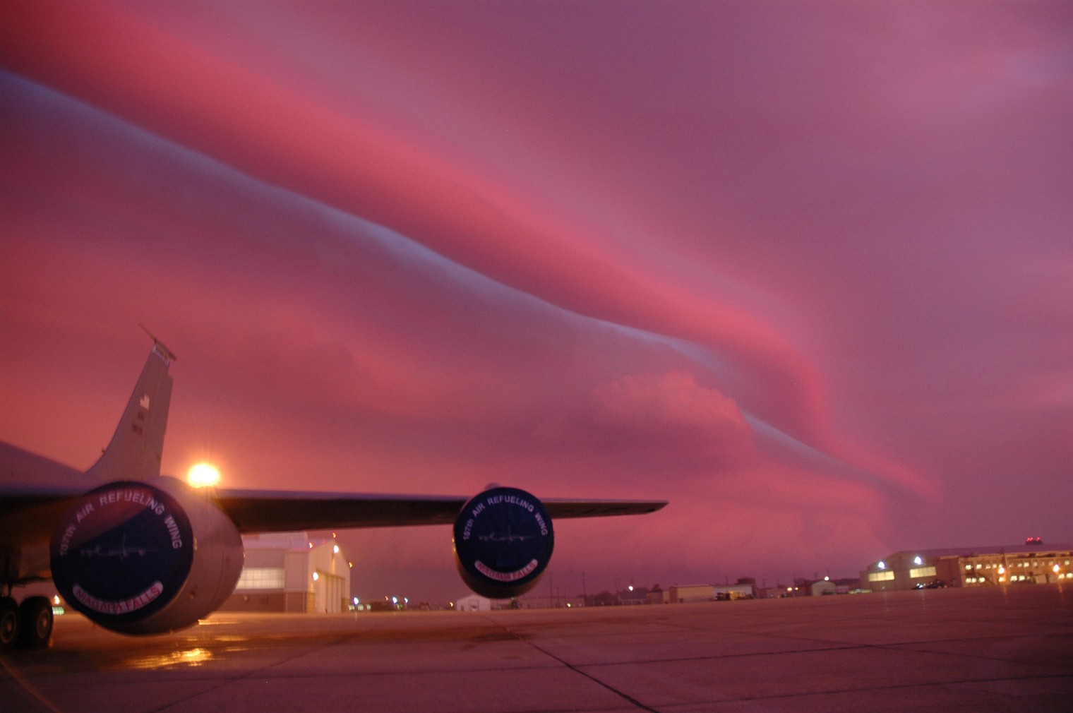 Airplane at sunset with lenticular clouds