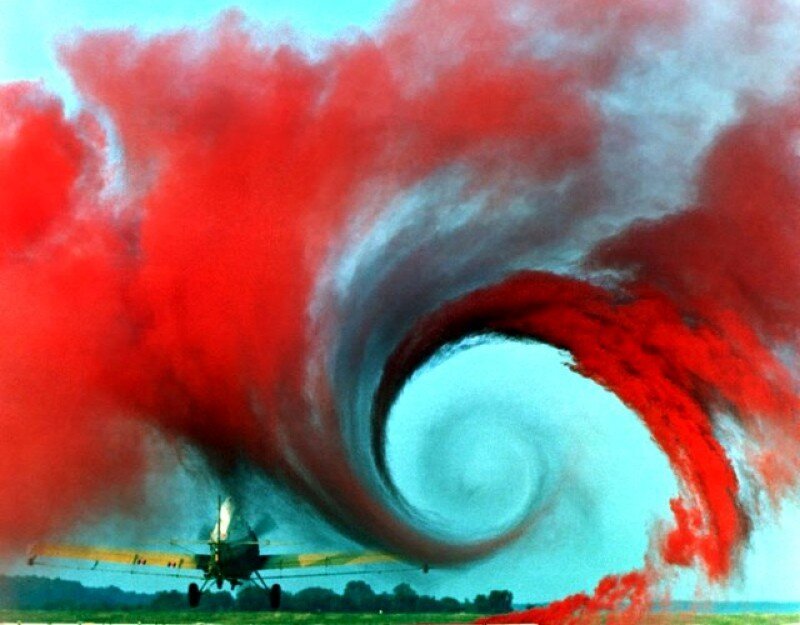 airplane creating red smoke vortex