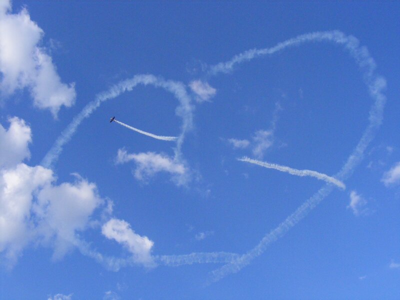 airplane drawing heart in sky