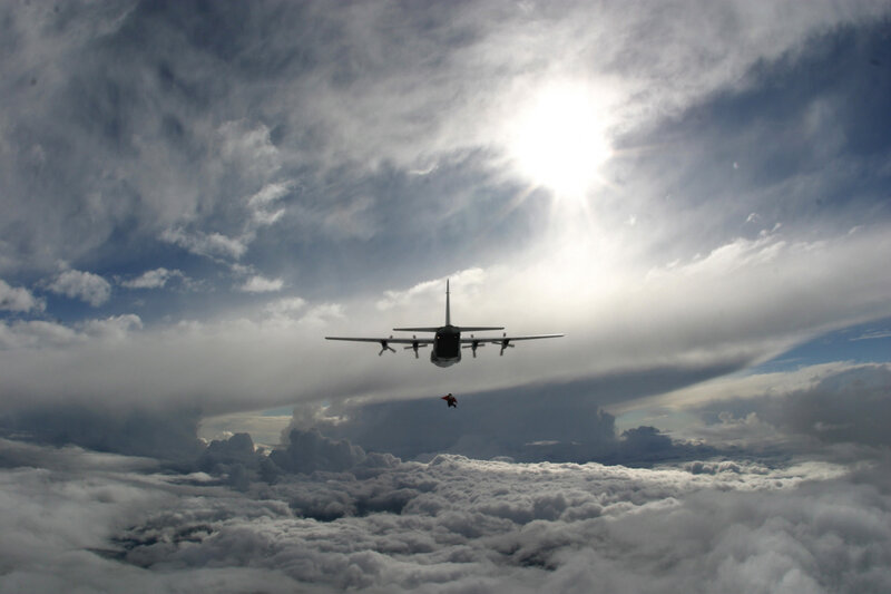 Airplane dropping paratrooper