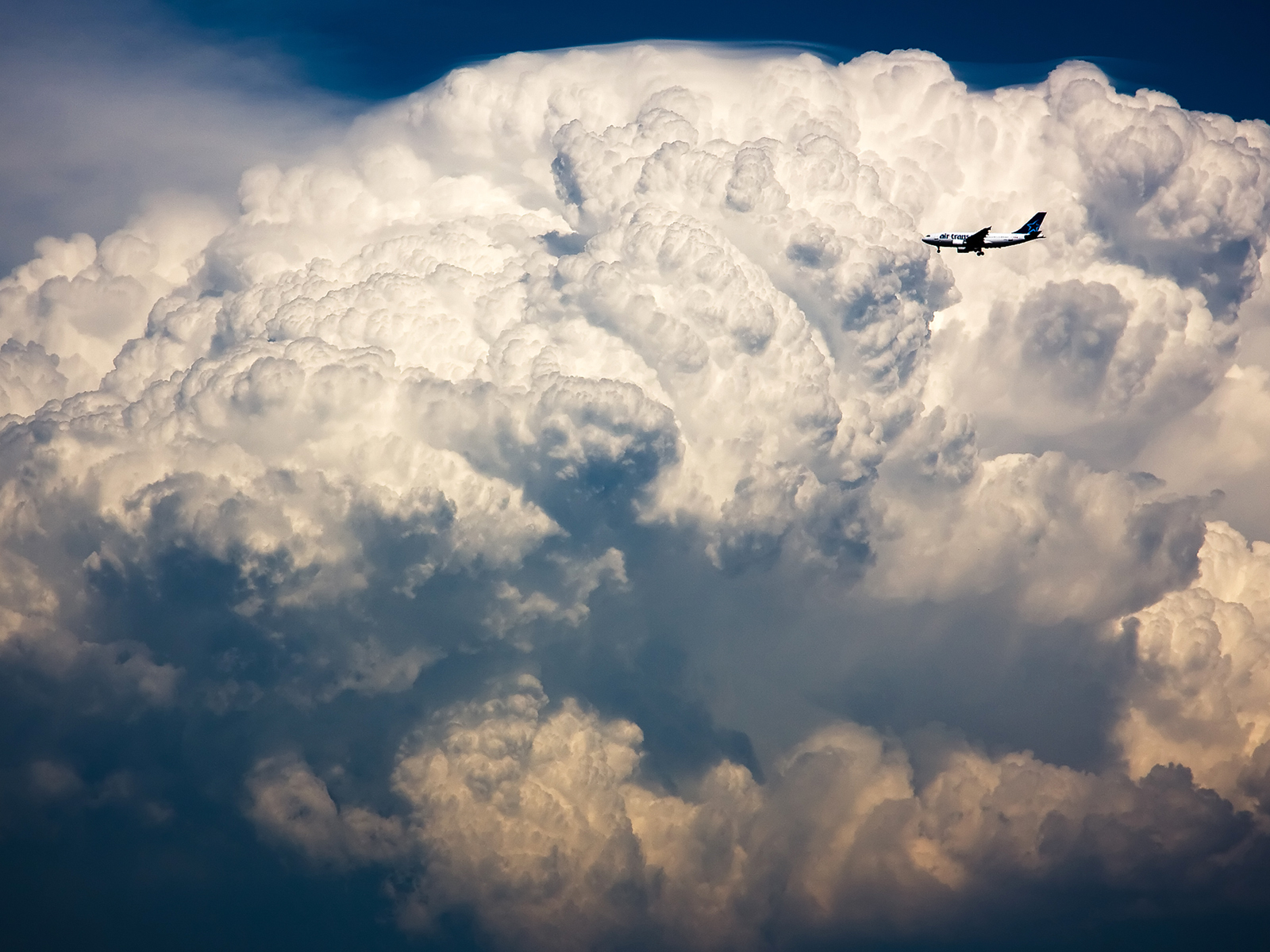 Airplane flying above storm clouds