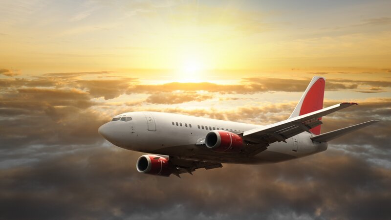 airplane flying at sunset