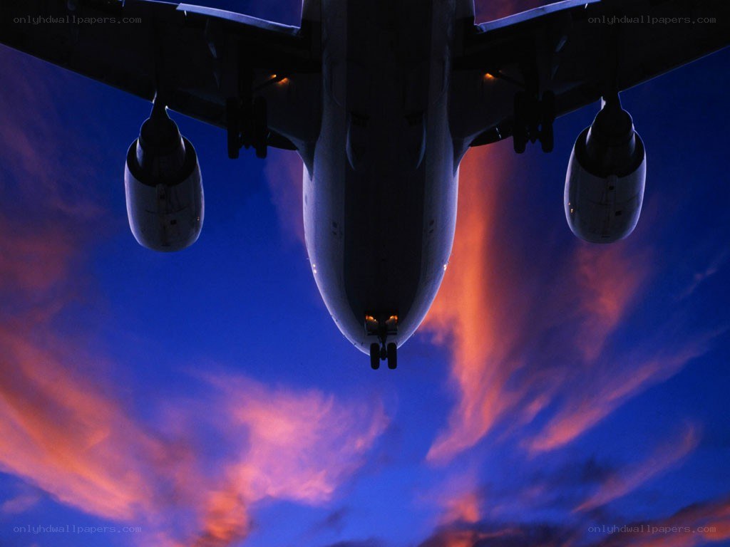 Airplane flying at sunset