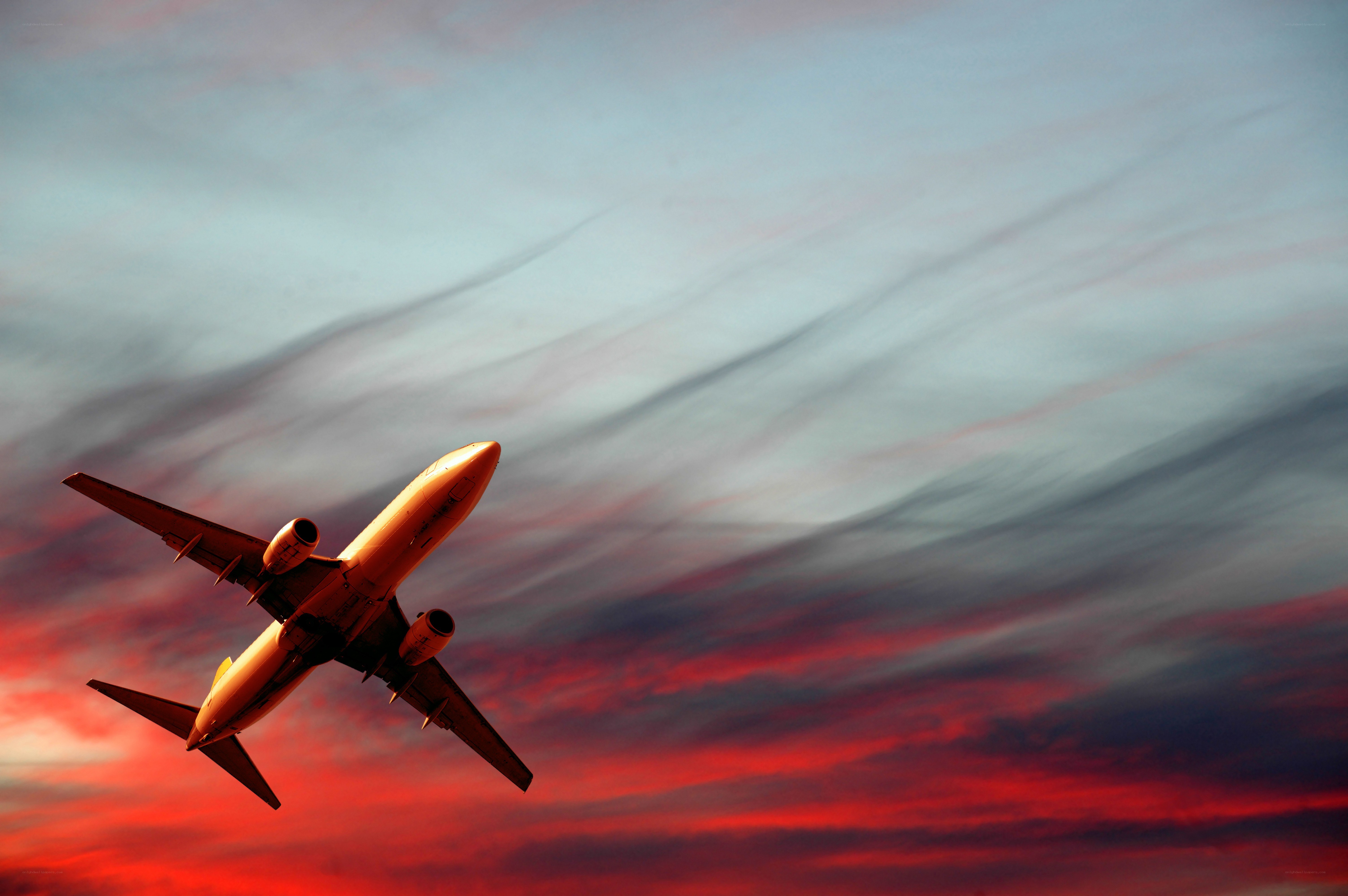 Airplane flying at sunset
