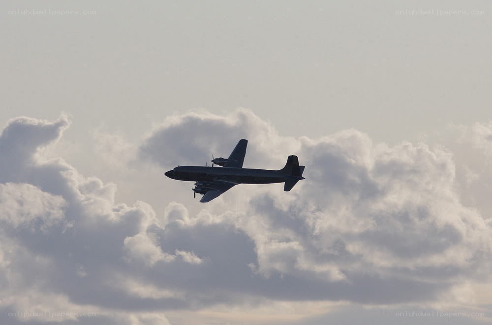 airplane flying in cloudy sky