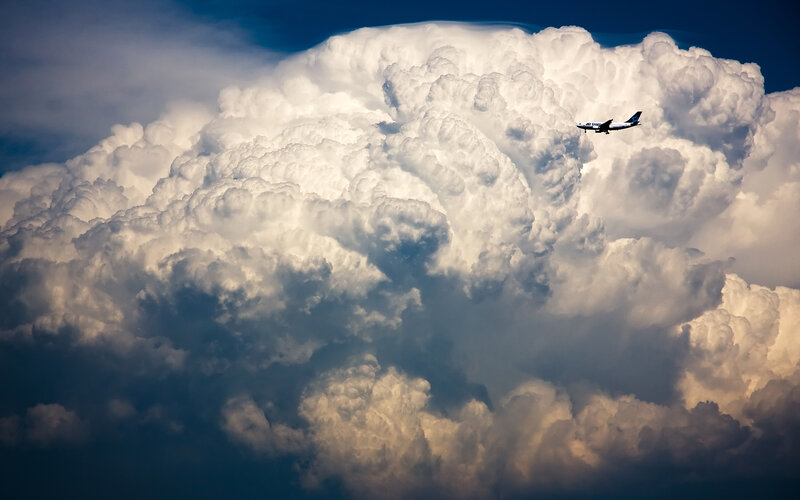 Airplane flying near storm cloud