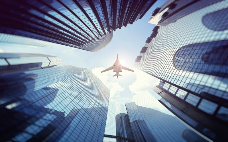 Airplane Flying over Buildings