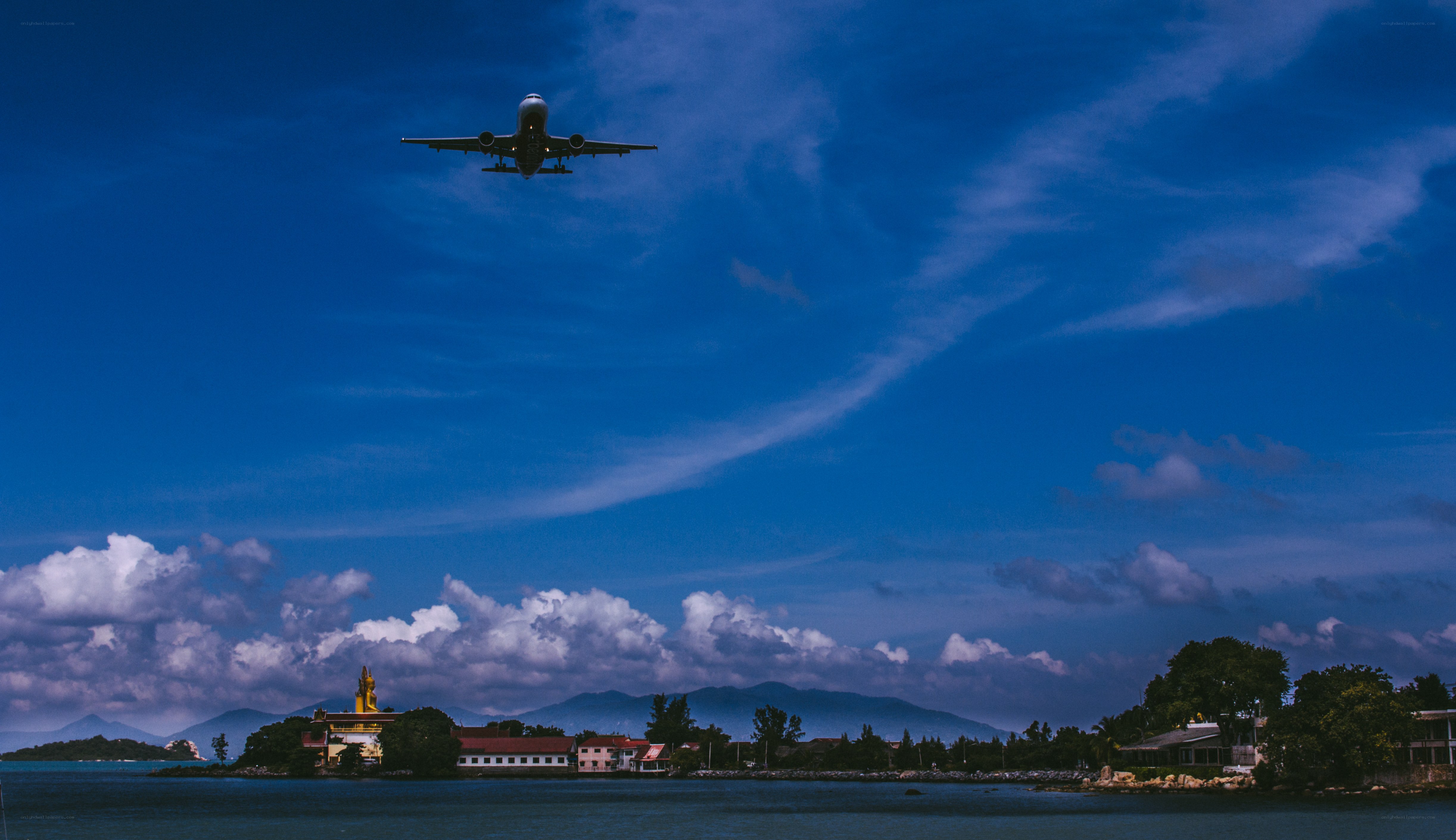 Airplane flying over coastal town