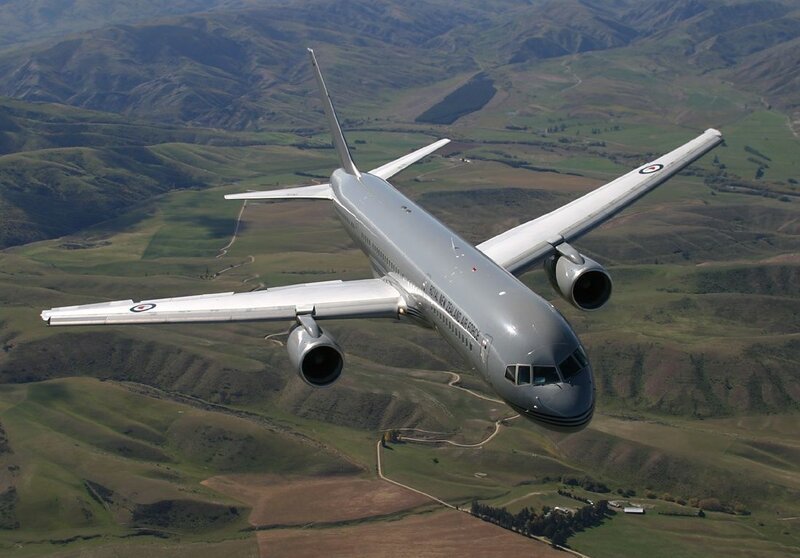 Airplane flying over green hills